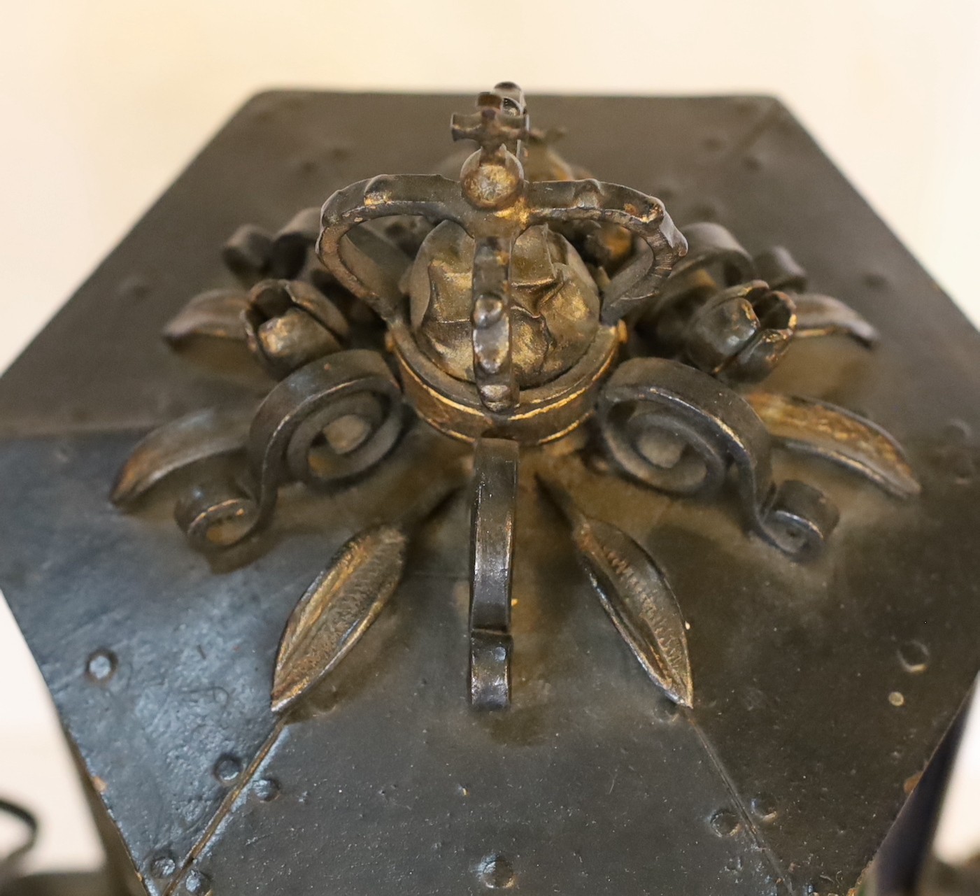 An early 20th century English wrought iron and stained-glass hexagonal lantern style table lamp with crown finial and parcel built black painted finish, height 50cm. width 32cm